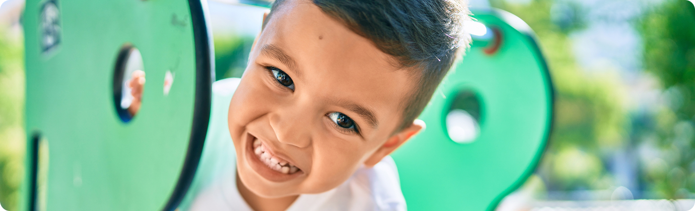 our-impact-2024-hero-image young boy smiling on playground